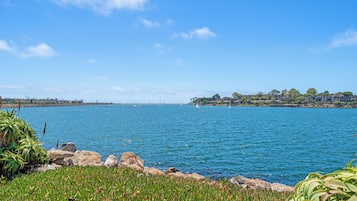 A coastal landscape with a clear sky, calm sea, and rocky shoreline.