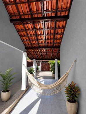 A hammock under a wooden ceiling, potted plants, and a gated entrance. - Vacation home in Araruama, near the lagoon. (Araruama)