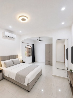 A modern bedroom with a bed, bedside table, air conditioning unit, ceiling fan, and a large mirror. - Vacation home in Araruama, near the lagoon. (Araruama)