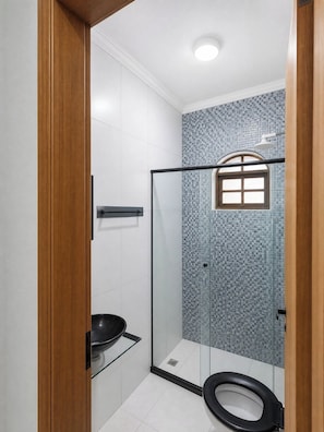 A bathroom with a glass shower enclosure, a toilet, and a sink. - Vacation home in Araruama, near the lagoon. (Araruama)