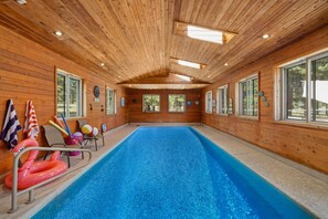 A wooden interior with a swimming pool, windows, and beach-themed decorations. - Luxury Estate with Indoor heated Pool, Spa & Casita (Flagstaff)