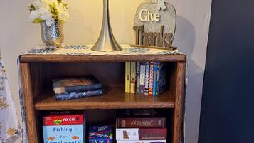 A wooden side table with a lamp, a 'Give Thanks' sign, and a vase of flowers.