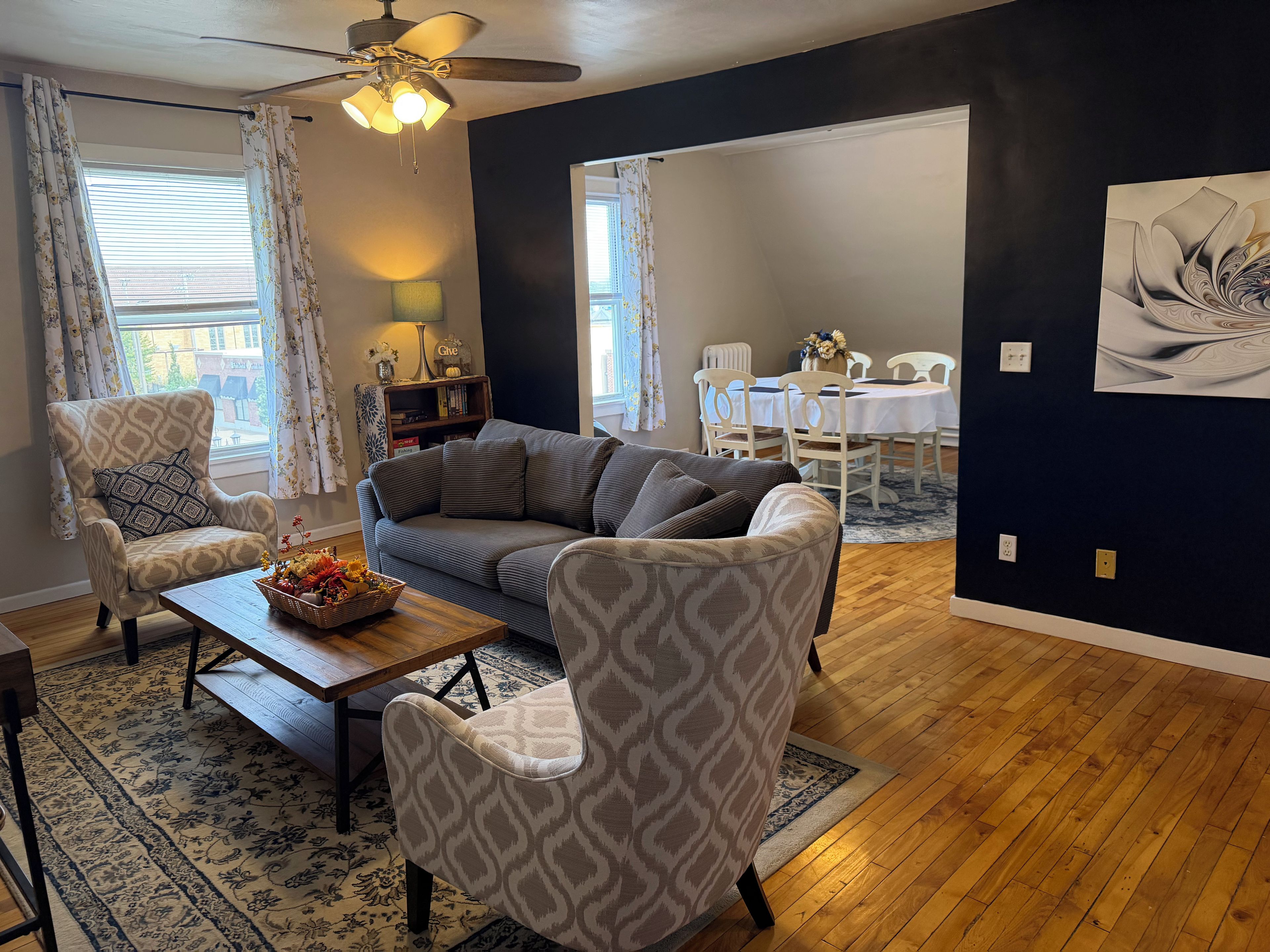 A living room with a sofa, armchairs, a coffee table, and a dining area with a table and chairs.