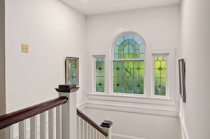 A staircase with white walls and a wooden handrail.