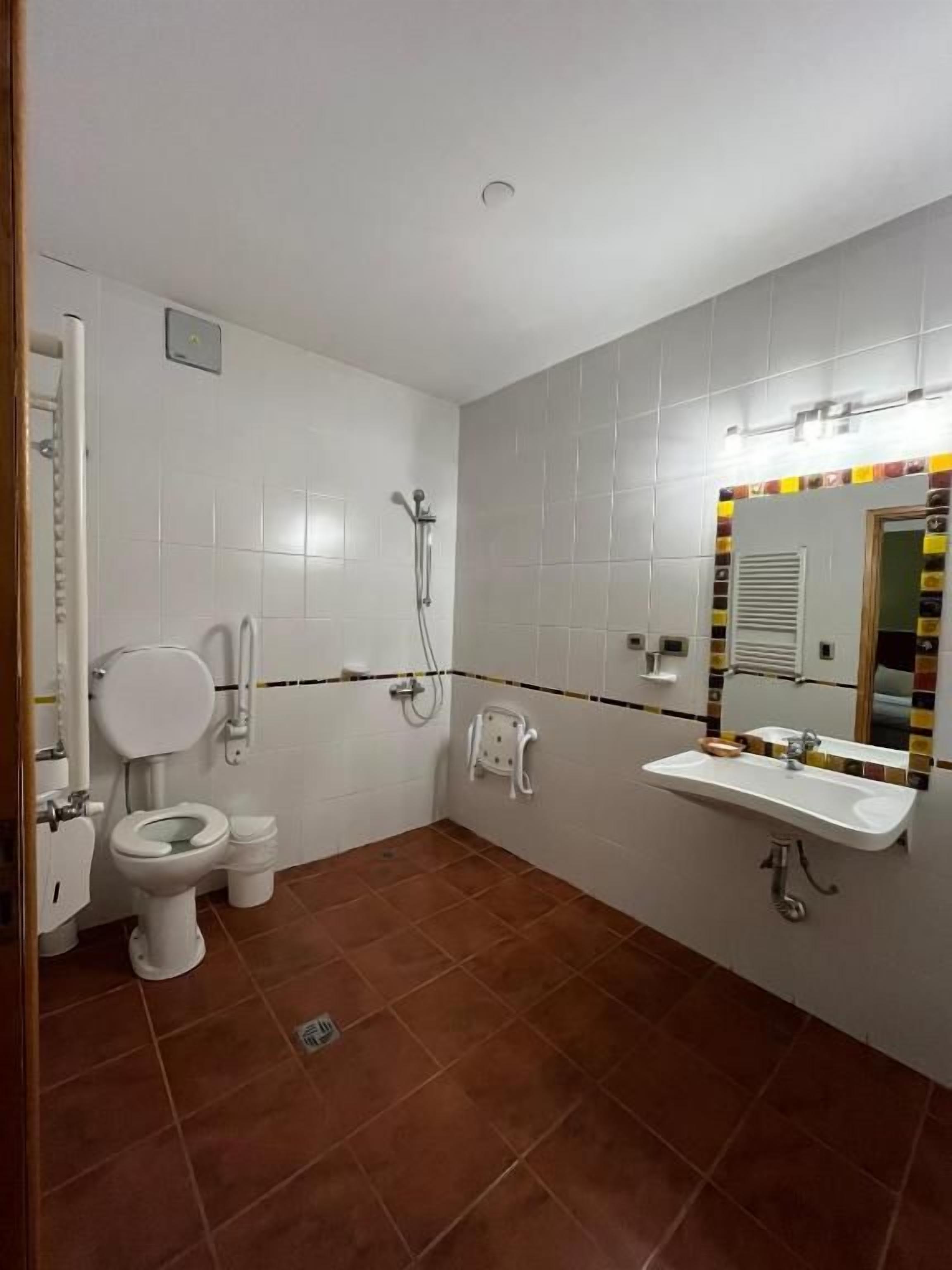 Une salle de bain comprenant des toilettes, un bidet, une douche et un lavabo.