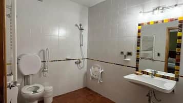 Une salle de bain comprenant des toilettes, un bidet, une douche et un lavabo.