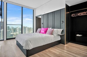 A modern bedroom with a large bed, a city view, and a black wardrobe. - E11EVEN 48th Floor Residence with City Views (Miami)