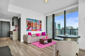 A modern living room with a large window, a sofa, a coffee table, and a city view. - E11EVEN 48th Floor Residence with City Views (Miami)