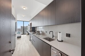 Eine moderne Küche mit großem Fenster, Spüle und Geschirrspüler.