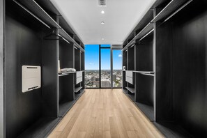 Een moderne hal met een houten vloer, zwarte wanden en een stadsgezicht door grote ramen.