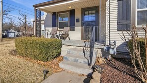 A residential house with a front porch, a garage, and a well-maintained lawn. - The Corner Charmer• Near TU/Expo/Downtown (Tulsa)