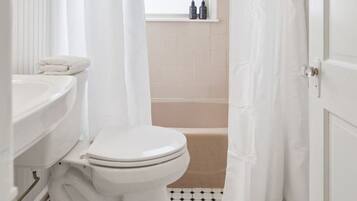Un baño con inodoro, lavamanos y bañera.