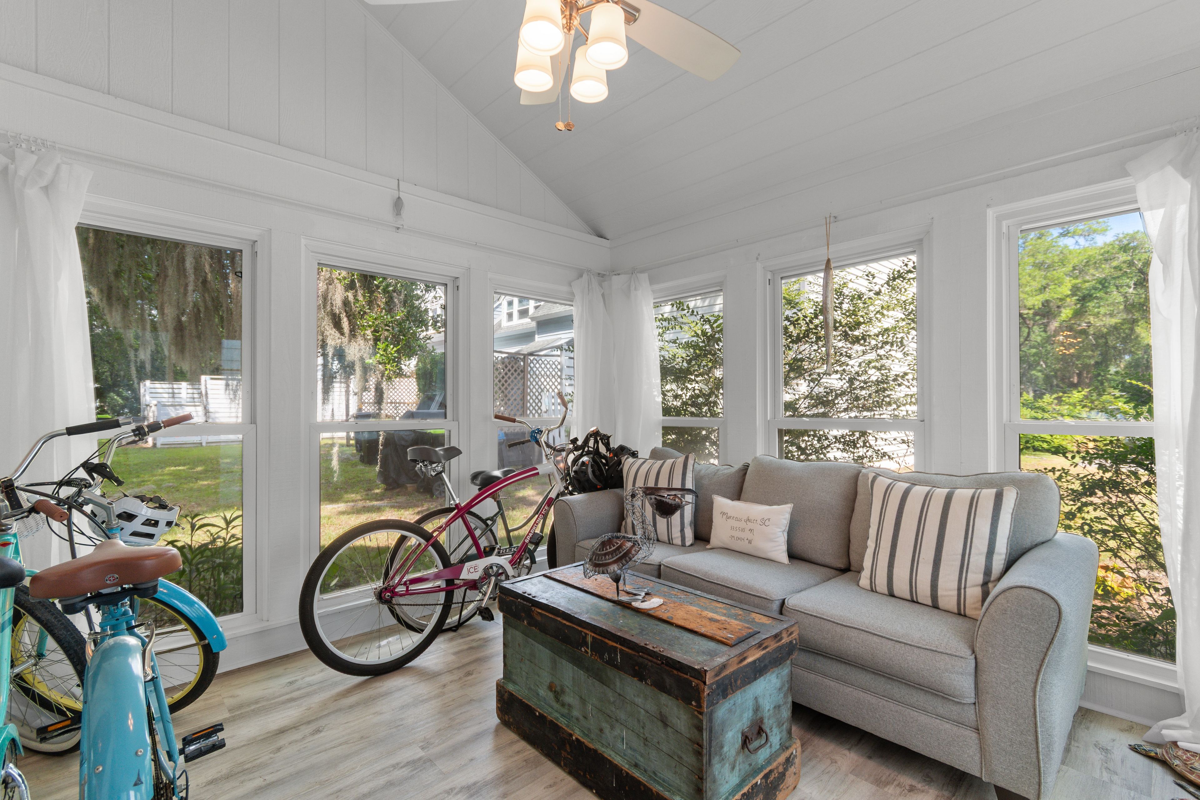 A sunroom with a sofa, a coffee table, and bicycles.