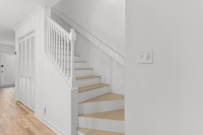 Eine Treppe mit weißen Geländern und Holzstufen.