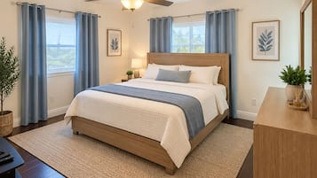 Une chambre à coucher comprenant un lit, un ventilateur de plafond, une table de chevet, une lampe, une plante en pot et une commode.