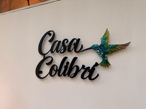 A wall sign with the text 'Casa Colibri' and a decorative bird.