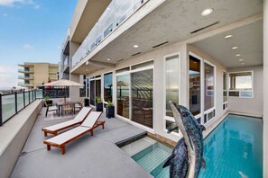 A rooftop pool area with lounge chairs, a dining table, and a statue. - Ocean Lane Luxury - 4B 4BA Private Elegance w Pool (Imperial Beach)