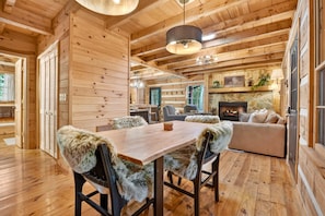 Un interior de madera con una mesa de comedor, sillas y una chimenea.