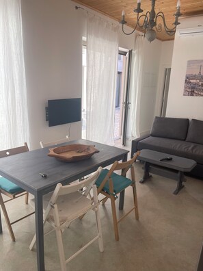 A dining area with a table, chairs, a television, and a sofa. - Cozy 1-bedroom apartment in fabulous Faro with AC/heating with private terrace (Faro)