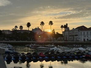 A marina with boats docked, a sunset in the background, and buildings along the waterfront. - Cozy 1-bedroom apartment in fabulous Faro with AC/heating with private terrace (Faro)