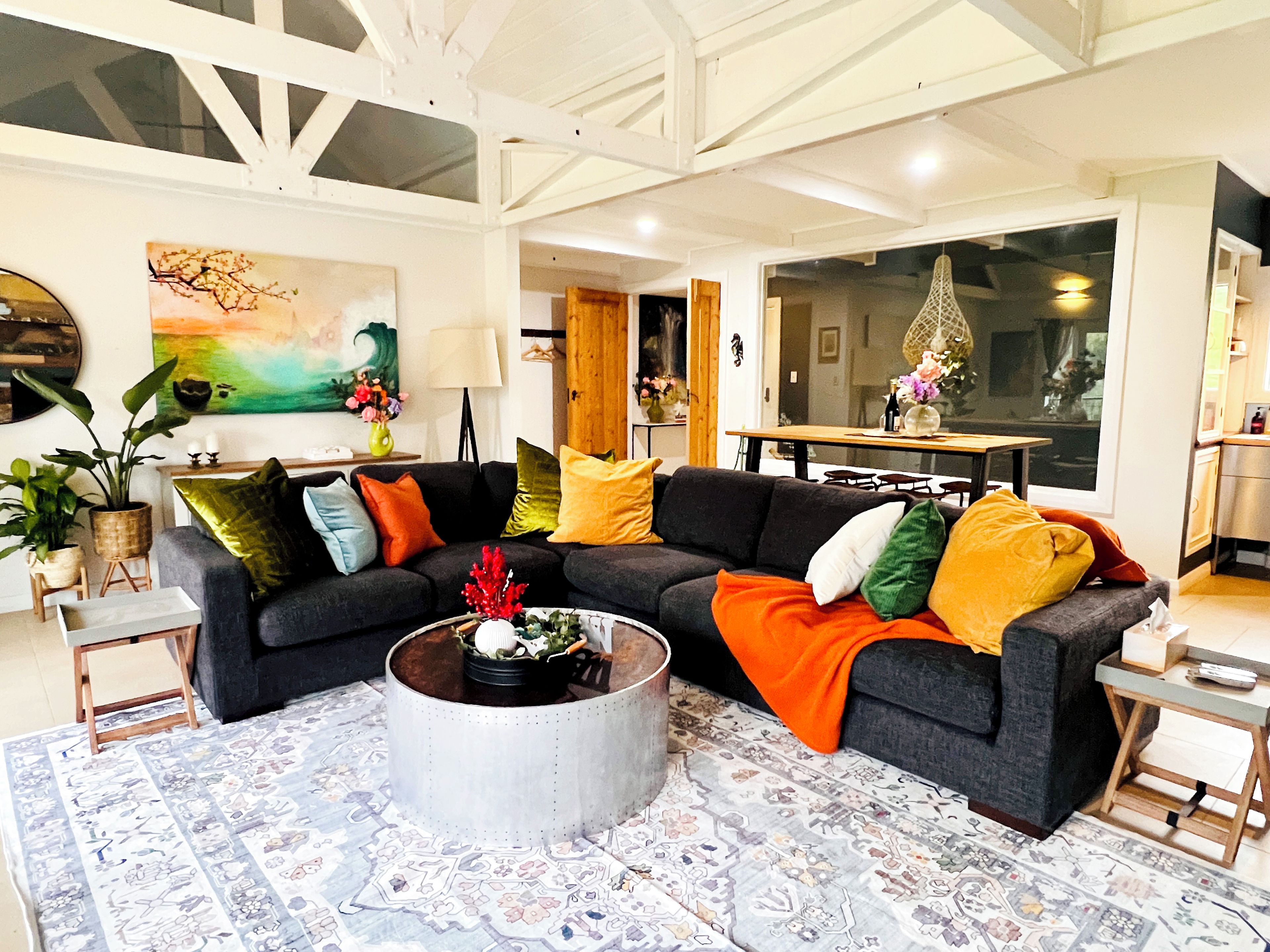 A modern living room with a sectional sofa, a coffee table, and a patterned rug.