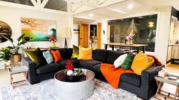 A modern living room with a sectional sofa, a coffee table, and a patterned rug.