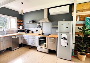 Une cuisine moderne dotée d’appareils électroménagers en acier inoxydable, de plans de travail en bois et d’un four encastré.