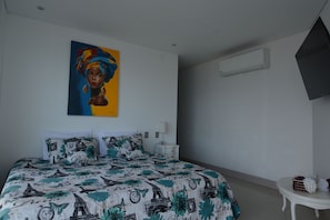 Una camera da letto con un letto, un comodino, un condizionatore d'aria a muro e un quadro.