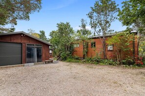 A two-story building with a gravel driveway and a covered carport.