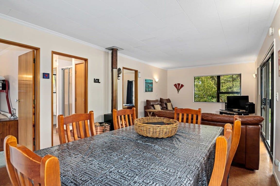 A dining area with a table, chairs, a television, and a window.