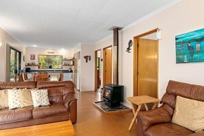 A living room with a brown leather sofa, a small wooden table, and a fireplace.