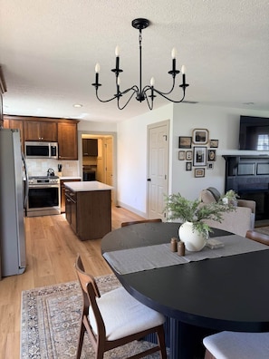 A modern kitchen with wooden cabinets, a built-in microwave, and a large island.
