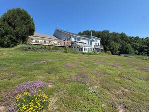 Ein zweistöckiges Haus mit einer großen Terrasse und Solaranlagen.