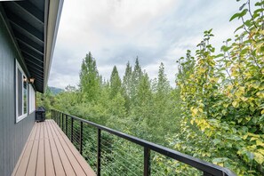 A wooden deck with a black railing overlooking a dense forest and a cloudy sky. - The Chugach Retreat-Spacious Luxury, Views & Hot Tub, Sleeps 10, FlexibleBooking (Anchorage)