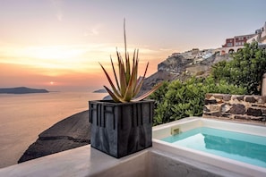 A pool with a view of the sea and a building on a cliff. - Golden Grey Goose - Adults Only (Santorini)