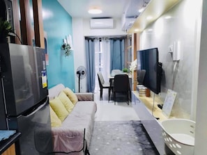 A compact living space with a kitchenette, a dining area, and a seating area with a sofa and chairs. - MOA Complex 1BR Shore 3 Tower 1 Unit 547 (Pasay)