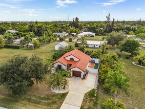 A residential area with houses, a red-roofed house in the foreground, and a clear sky. - NEW!! Bokeelia Bonita! Pool 2 bed 2 bath home! (Bokeelia)