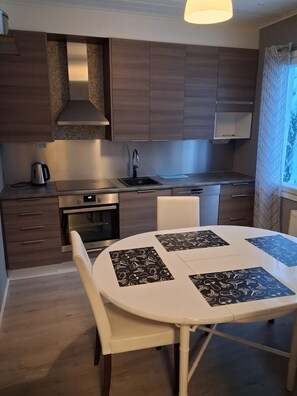 A modern kitchen with wooden cabinets, a stainless steel sink, and a built-in oven.