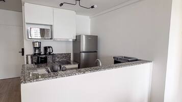 Una cocina moderna con una isla integrada, electrodomésticos de acero inoxidable y encimera de granito.