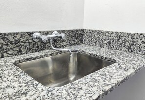 Un lavamanos de acero inoxidable con encimera de granito.