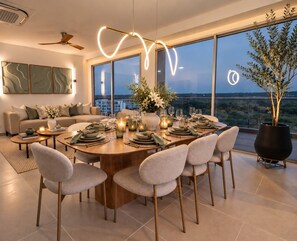 A modern dining area with a round table set for six, surrounded by six chairs. - Luxury 3-Bedroom Penthouse  Crystal Lagoon & White-Sand Beach (Cartagena de indias)