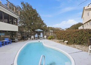 A swimming pool with a deck area, surrounded by a wooden fence and trees. - Welcome to your ultimate coastal escape! 2min walk to a private beach (Kitty Hawk)