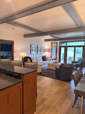 A modern kitchen with granite countertops and wooden cabinets, a dining area with a wooden table, and a living room with a sofa and chairs. - Snow Cloud Slope Side Dream
3 bedroom/3 1/2 bath ski in/ski out (Avon)