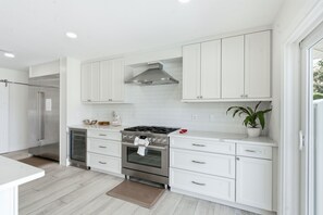 A modern kitchen with white cabinetry, a stainless steel range, and a built-in oven. - The Beach Life - 4 BR 2.5 BA  premier home w/ pool & waterview (Indian Rocks Beach)