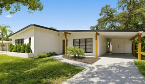 A modern two-story house with a covered porch, a small garden, and a well-maintained lawn. - Central Tampa Oasis : Near Stadium, Downtown & TPA (Tampa)