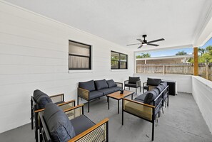 Eine Außenpatio mit einer Couch, Stühlen und einem Tisch.