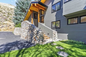 A modern house with a stone staircase leading to a wooden deck. - Sage Haven | Walk to Ski + Hot Tub & Deck (Ketchum)