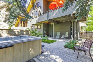 Une maison à deux étages dotée d’un jacuzzi, d’un espace salon extérieur et d’une terrasse couverte.