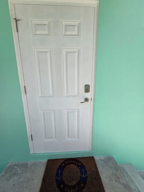 Una puerta blanca con un ojo de cerradura y un timbre.