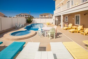 Un jardin avec une piscine, des chaises longues et une table de patio.